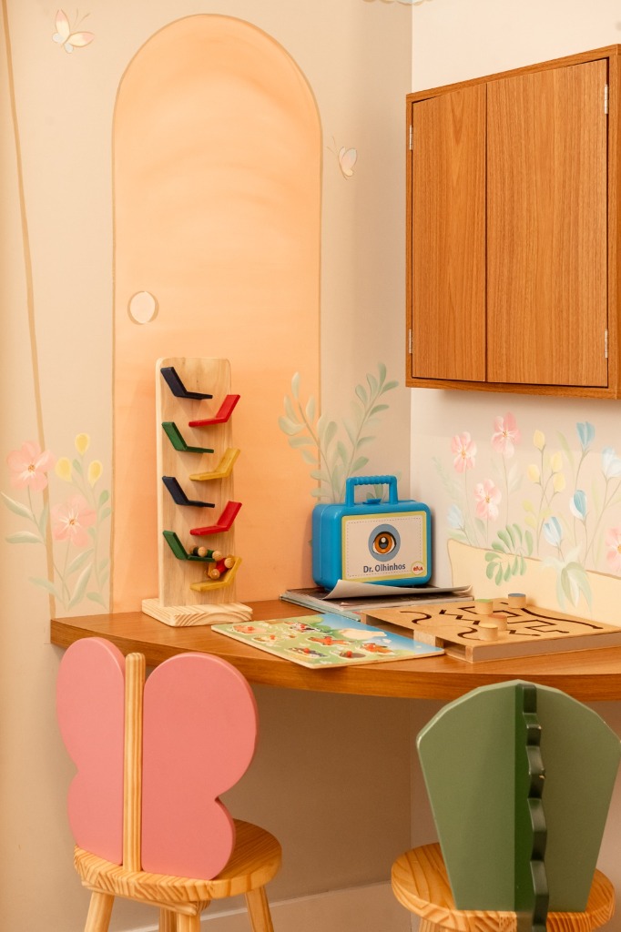 Espaço infantil lúdico com mesinha, brinquedos e cadeiras temáticas